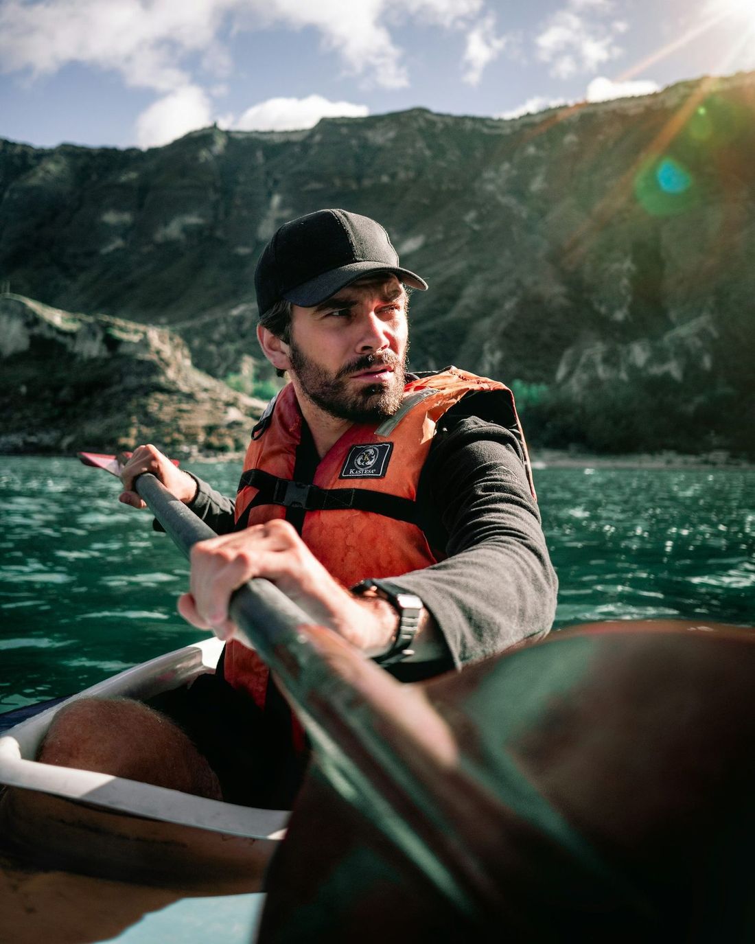 A man in a buoyancy aid paddling a kayak